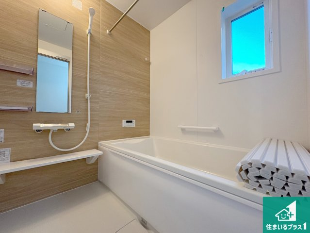 八幡市男山松里　第3期　新築一戸建ての浴室|足をゆったり伸ばして寛げる浴槽です。窓が設けられていますので差し込む光が明るく穏やかな雰囲気にしてくれます♪浴室乾燥機も設置しているので、雨の日の洗濯物も安心です♪
