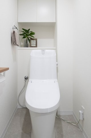 リーベン江波南のトイレ|トイレには小物を収納できる吊戸棚が設置されています。