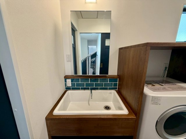 沖縄市諸見里戸建・Ａ棟の独立洗面台|水撥ね防止のタイルがお洒落な、洗面化粧台