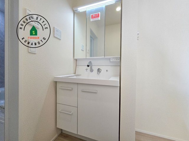 熊本市東区小峯4丁目第1-2棟（1号棟）の内観：施工例|毎日使うものだから清潔な空間を保ちたい水回り。洗面にはそんな願いを解消させてくれる収納アイデアが満載です。三面鏡の裏側にはキャビネットが現れ小物から背の高い物まで収納できます。