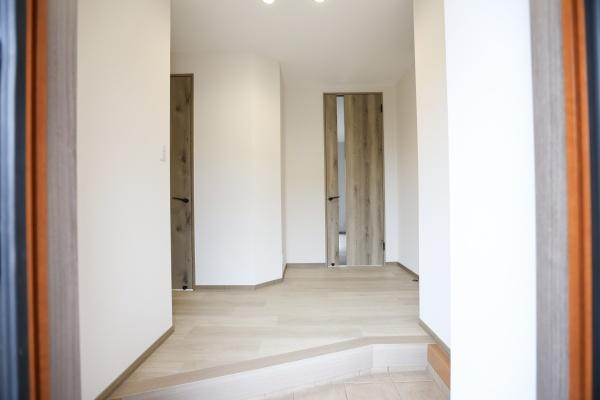 田尻南一丁目　中古の玄関|玄関は明るく開放感のある空間です。シンプルなデザインで清潔感が感じられます。ゆとりのある設計が印象的です。木目調のドアが落ち着いた雰囲気を演出しています。段差部分も使いやすい設計です。