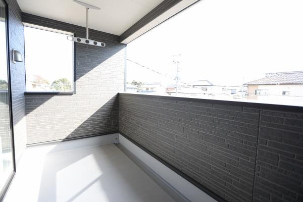 荏隈第3-2号棟の玄関|シンプルなデザインの玄関で落ち着いた色合いが印象的です。玄関先には屋根があり天候の影響を受けにくい設計です。清潔感のあるタイルとモダンなドアが魅力です。外部からのアプローチもスムーズに行えます。