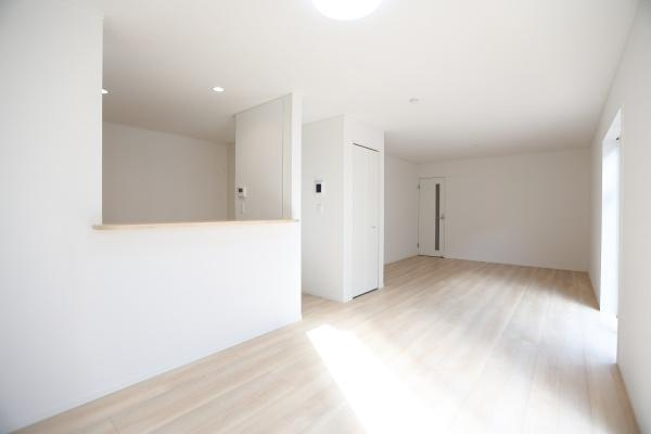 荏隈第3-2号棟の居間・リビング|リビングには大きな窓があり明るさを感じられます。ホワイト系の内装で空間が広く見えます。床はナチュラルな色合いです。室内全体がすっきりとしています。シンプルなデザインが特徴です。