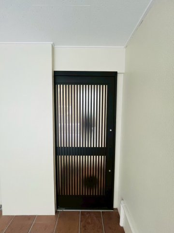 寝屋川市高柳1丁目中古戸建の玄関|採光デザインの玄関ドアです。道路からは見えづらいガレージの中にあるため、お家の中が見えてしまう心配はあまりありません。