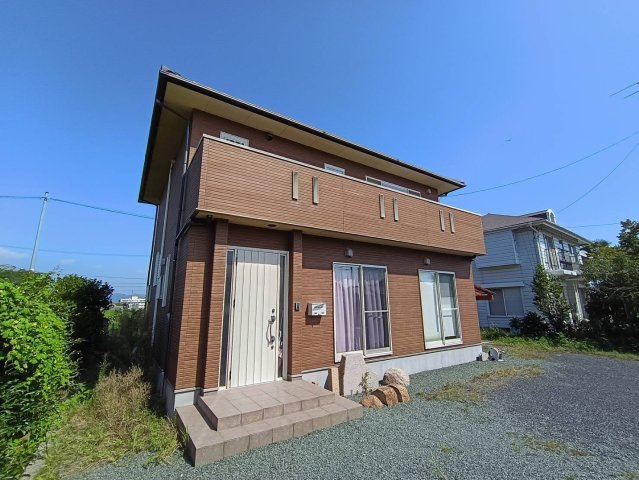西条市周布892-5　中古住宅の外観|側道路に面し、陽光を全身に浴びる明るい外観。清潔感のあるデザインは、周囲の穏やかな住環境と調和する。広い敷地を活かしたアプローチが、住む人とゲストを優しく迎え入れる家の顔。