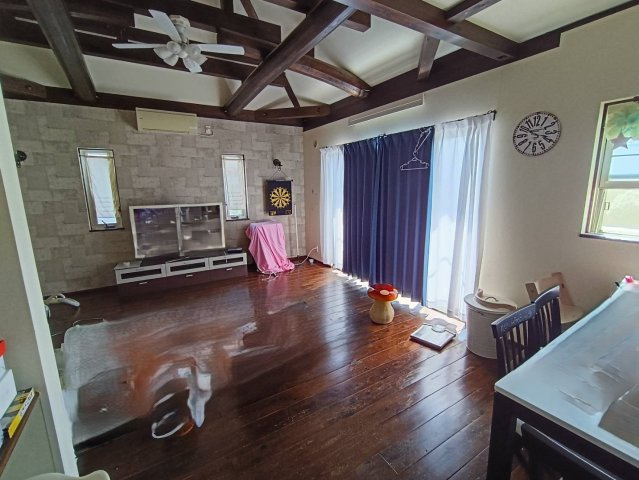 西条市周布892-5　中古住宅の居間・リビング|南向きの大きな窓からたっぷりと陽光が降り注ぐ、家族の集いの場。110坪の広い敷地を活かした庭との繋がりを感じられ、開放感あふれる暮らしが叶う。ソファを置いてゆったりと寛げる、家の中心となる空間。