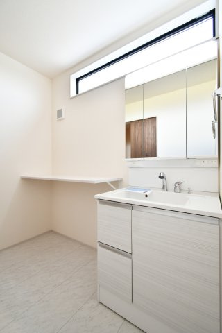 さいたま市岩槻区南辻第3　1号棟の独立洗面台|洗面化粧台は三面鏡を採用しており、鏡裏までスペースを余すことなく収納することが出来ます。お隣はランドリー棚となっておりますので、下段にはランドリーボックス、上段では洗濯物をたたむことが出来ます。