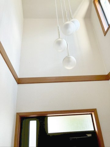 福岡市東区美和台5丁目　中古戸建の内装|吹抜けの高い位置から光が差し込み、玄関全体を明るい印象に！