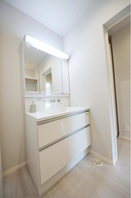 亀山南1丁目の洗面所|洗面所には収納スペースとガス乾燥機があります