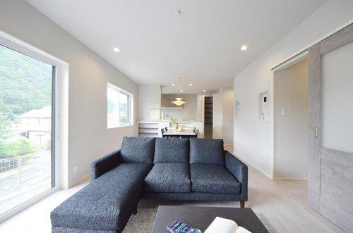 亀山南1丁目の居間・リビング|吹き抜けのある開放的なリビング空間。オープンタイプの対面式キッチンでリビングが隅まで見渡せます。キッチンにいながら小さなお子様にも目が届き安心です。