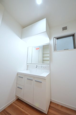 海老園四丁目の洗面所|清潔感あふれる白を基調としたシャワー付洗面台と洗面室。収納棚もある余裕のスペース。窓もあり明るく通気も良いです。