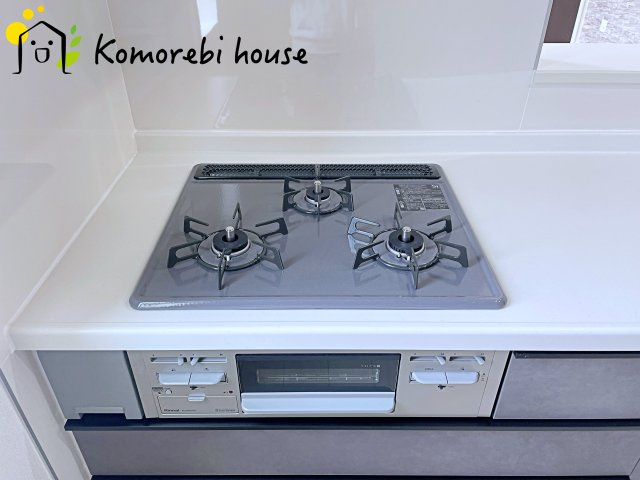 桶川市上日出谷南　4期　新築一戸建て　グラファーレ　01のキッチン|同時調理が叶う3口コンロと便利なグリル付き。忙しい朝のお弁当作りも、夕食の複数メニューもスムーズにこなせる頼れる設備です。