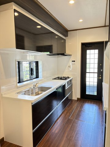 大和西1丁目　中古戸建のキッチン|新調されたシステムキッチンです。食器洗い乾燥機付きで、忙しい毎日も大助かり！
勝手口もあり、明るく便利なキッチンスペースですね！