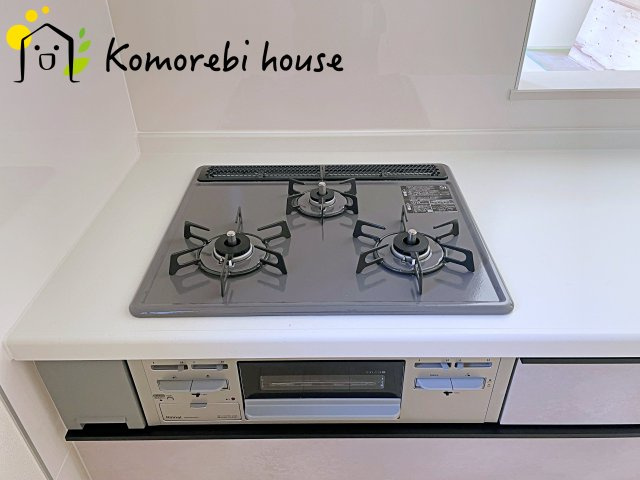 桶川市坂田971番　新築一戸建て　ハートフルタウン　Aのキッチン|同時調理が叶う3口コンロと便利なグリル付き。忙しい朝のお弁当作りも、夕食の複数メニューもスムーズにこなせる頼れる設備です。