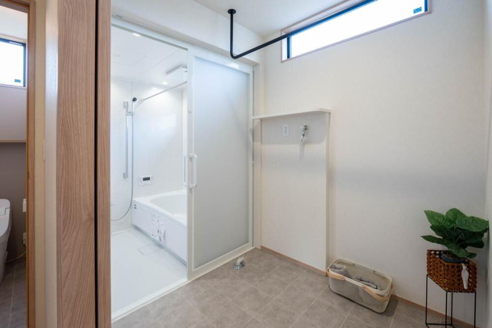 万代ホーム様　西浜新築一戸建てのランドリースペース|脱衣室兼ランドリールームも2帖。室内干しが出来るので雨や火山灰の心配もナシ！洗濯→収納がこの部屋で完結します