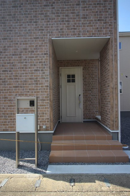 小山市西城南7丁目　第5　1号棟の玄関|レンガ調の壁に映える玄関ドアが印象的！屋根付きポーチなので雨の日も濡れにくく、快適に出入りできます。