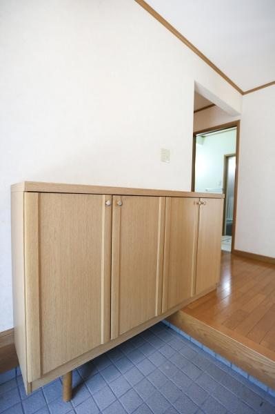望みが丘　中古の玄関|落ち着いた色合いの玄関はシンプルですっきりとした印象です。木製の収納が備わっており無駄のない空間設計が魅力です。段差部分とタイルが区切りを生みメリハリのある玄関です。清潔感が感じられる雰囲気です。