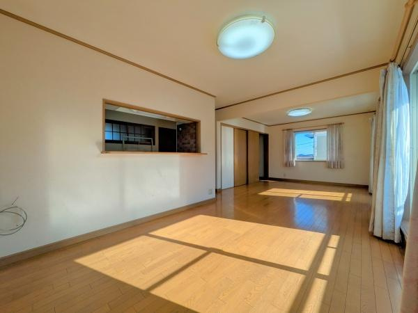 望みが丘　中古の居間・リビング|大きな窓から光が差し込む明るいリビングです。木目調のフローリングが温かみを演出しています。カウンターキッチン付きで使い勝手も良好です。広々とした空間で様々なインテリアに対応します。