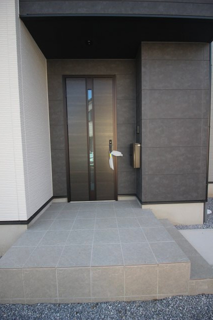 壬生町幸町1丁目　41期　2号棟の玄関|スタイリッシュな印象の玄関ドアが住まいの顔に。タイル敷きのアプローチは段差も少なく、ベビーカーや荷物の出入りもスムーズです。