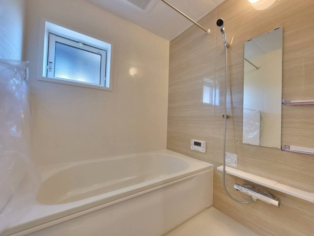 【ブルーミングガーデン】下野市川中子 全2邸の浴室|〇2号棟　浴室○
白と木目柄が、清潔で落ち着いた雰囲気を醸す浴室。1日の疲れをゆっくりと癒すことができる。雨の日には浴室内に洗濯物を干すこともできる、機能性も備えています。
※2025年11月撮影