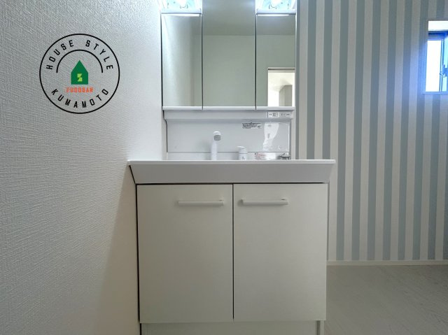 熊本市西区谷尾崎町第1-2棟（1号棟）　の内観：施工例|毎日使うものだから清潔な空間を保ちたい水回り。洗面にはそんな願いを解消させてくれる収納アイデアが満載です。三面鏡の裏側にはキャビネットが現れ小物から背の高い物まで収納できます。