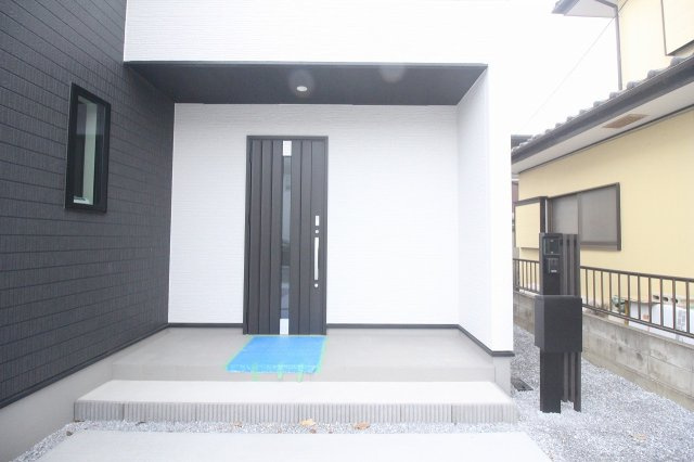小山市犬塚3丁目　3期の玄関|奥行きある玄関ポーチで雨の日も濡れにくい造りです。スタイリッシュなダークカラーの玄関ドアが外観にマッチし、来客時の印象もぐっと良くなります。