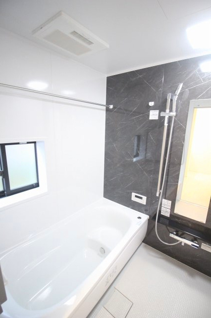 小山市犬塚3丁目　3期の浴室|落ち着いた石目調パネルが高級感ある浴室。換気しやすい窓付きで、湿気対策も安心です。広めの浴槽で一日の疲れをゆったり癒せる空間になっています。