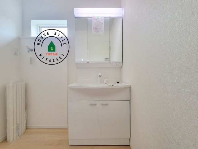 宮崎市恒久第15-1棟（1号棟）の独立洗面台|毎日使うものだから清潔な空間を保ちたい水回り。洗面にはそんな願いを解消させてくれる収納アイデアが満載です。三面鏡の裏側にはキャビネットが現れ小物から背の高い物まで収納できます。