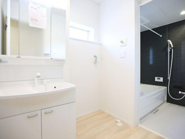 久原中央第4-1号棟の独立洗面台|洗面台はシンプルなデザインで使いやすく空間がすっきりとしています。バスルームへアクセスしやすいレイアウトです。便利な収納スペースも備えています。明るい色調で清潔感ある印象です。