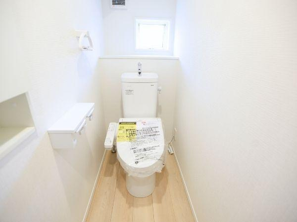 久原中央第4-1号棟のトイレ|明るい空間が広がるトイレはシンプルで清潔感があります。窓から自然光が入り換気もしやすい設計です。白を基調とした室内が広がりを感じさせます。床材の色味が落ち着いた雰囲気を演出しています。