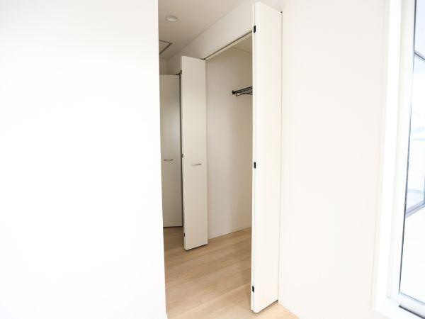 久原中央第4-1号棟の収納|シンプルな内装で収納スペースとして使いやすい設計です。折れ戸タイプの扉がスペースを有効活用できます。室内が明るくクローゼットの奥まで見渡せるのが特徴です。収納内部にもハンガーパイプが設置されています。