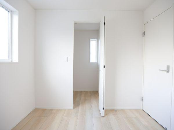 久原中央第4-1号棟の洋室|明るい色合いの床と壁が洋室全体をすっきりと演出しています。二面の窓から自然光が入りやすく開放感があります。ドアの先には別空間があり利便性を感じられます。シンプルなデザインでお手入れもしやすそうです。