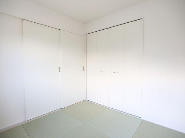 久原中央第4-1号棟の和室|すっきりとしたデザインの和室で清潔感があります。白を基調とした壁と収納が空間に広がりを感じさせます。畳の質感が落ち着いた雰囲気を演出しています。収納スペースも豊富で使い勝手が良い印象です。