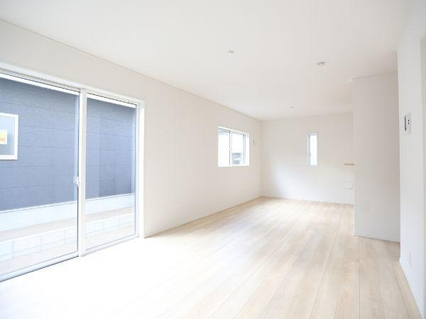 久原中央第4-1号棟の居間・リビング|白を基調としたリビングは明るく開放感があります。大きな窓から自然光がたっぷり差し込みます。シンプルなデザインが空間を広く感じさせます。床材の色合いが空間全体を柔らかく演出します。