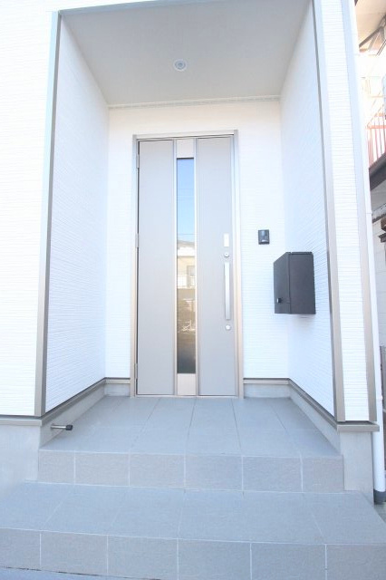 小山市間々田　第10　1号棟の玄関|シンプルで落ち着いた色合いの玄関ドア。屋根付きポーチで雨の日も出入りしやすく、来客時も好印象を与えてくれます。