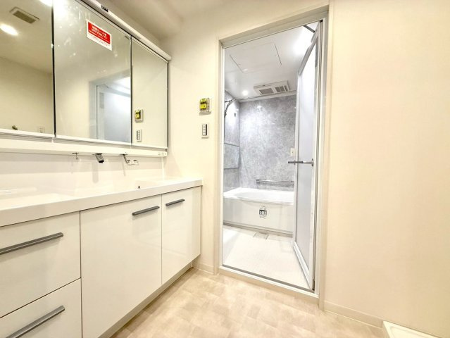 ディアコート横浜関内の独立洗面台|三面鏡と広々カウンターを備えた洗面室。清潔感ある白を基調に、収納力も兼ね備えた機能美あふれる空間です。