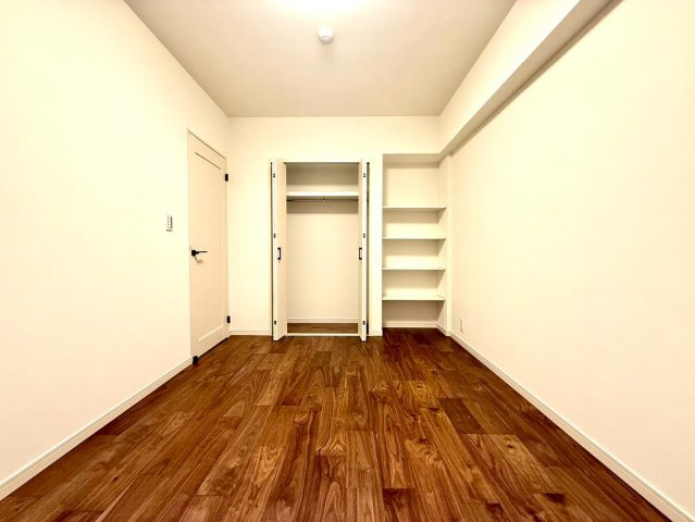 ディアコート横浜関内の洋室|クローゼットに加えオープン棚も設置された洋室。機能性と美しさを両立した、快適で整然とした空間です。