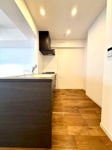 ディアコート横浜関内のキッチン|木目フローリングと調和するシックなキッチン。料理の時間を豊かに彩る、上質な住まいの中心空間です。