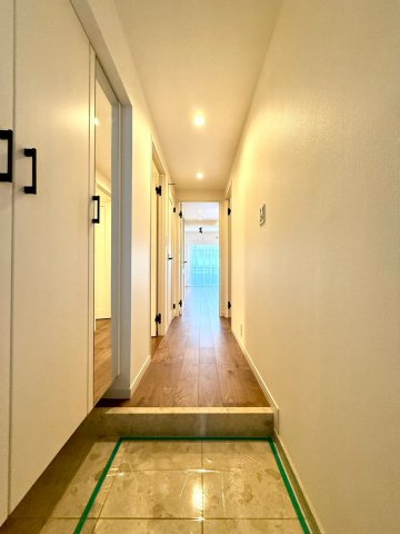 ディアコート横浜関内の玄関|ダウンライトが柔らかく照らす廊下は、奥行きを感じさせる上質な導線。住まいへの期待を高める空間設計です。