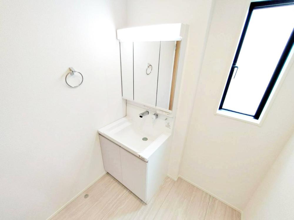 【GRAFARE　ZEH水準仕様】東久留米市八幡町３期の洗面所|三面鏡ならではの収納力、温水シャワー付きの機能性、どちらも採用！汚れが落ち易い大型の洗面ボウルは手入れもしやすく日々の生活を陰ながら支えてくれる仕様となっております