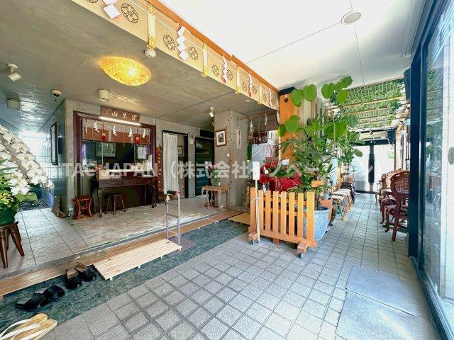 アーバンデザイナー設計・重厚SRC邸宅の玄関|1階の南側には多数のFIX窓があり日当たりの良い待合スペースが。大きな自動ドアをくぐると八津御嶽神社の受付になります。