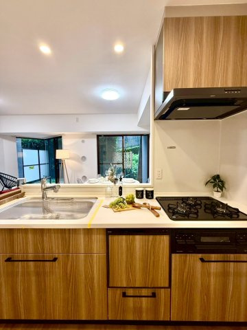 ナイスパークステージ横濱鶴ヶ峰のキッチン|木目調のシステムキッチン。食洗機・浄水器付きで、機能性とデザインを両立しています。