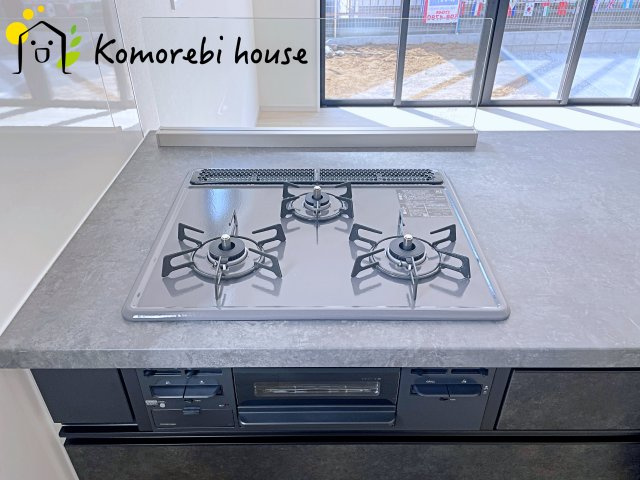 桶川市北　10期　新築一戸建て　グレース　01のキッチン|同時調理が叶う3口コンロと便利なグリル付き。忙しい朝のお弁当作りも、夕食の複数メニューもスムーズにこなせる頼れる設備です。