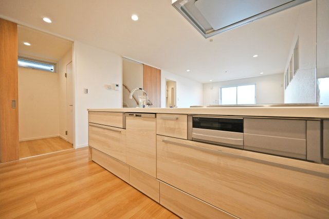 マドレコート甲南台新築一戸建て|4LDK+駐車2台可(車種制限有)のキッチン|1階キッチン奥側から撮影した写真です。コンロ前は視界を確保した耐熱パネル使用。IHコンロで掃除がらくらく！深型食機が搭載されています。