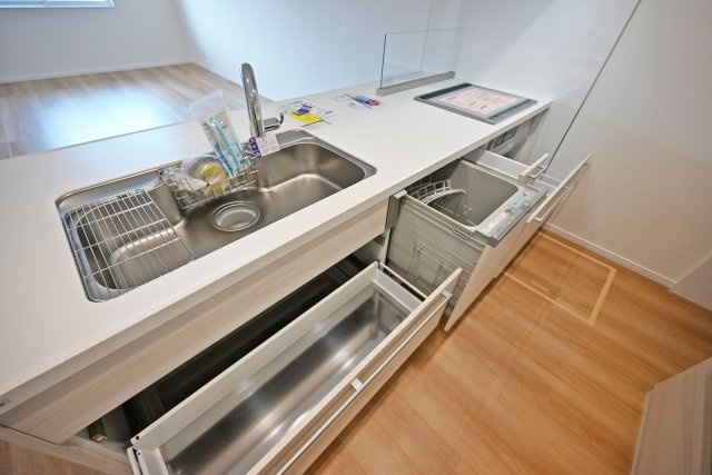 マドレコート甲南台新築一戸建て|4LDK+駐車2台可(車種制限有)のキッチン|ワークトップは十分な広さがあるW2550タイプ。調理台下いっぱいに収納を設け、包丁のホルダーや調味料専用の引き出しも備えています。本分譲地は食洗機が標準装備されています。