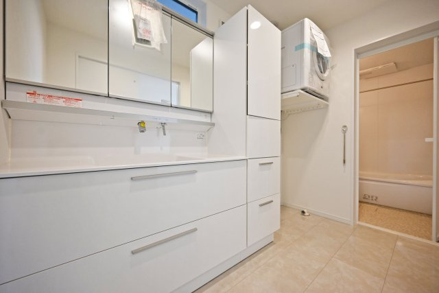 マドレコート甲南台新築一戸建て|4LDK+駐車2台可(車種制限有)の独立洗面台|収納量が豊富な[LIXIL製」の三面鏡の洗面化粧台。子供の成長に伴い、物が増えても安心の収納力。洗面室には幹太くんと室内干し用のホスクリーン竿が設置されます。