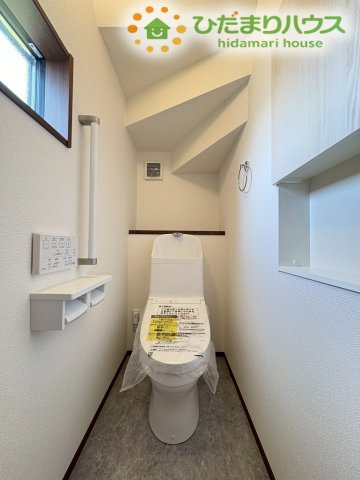 深谷市萱場　第10期　新築一戸建て　ワイウッドコート　06のトイレ|階段下のスペースを有効活用した、小窓付きの明るく清潔感のあるトイレです！手すりやペーパーホルダーも使いやすい位置に配置されています♪