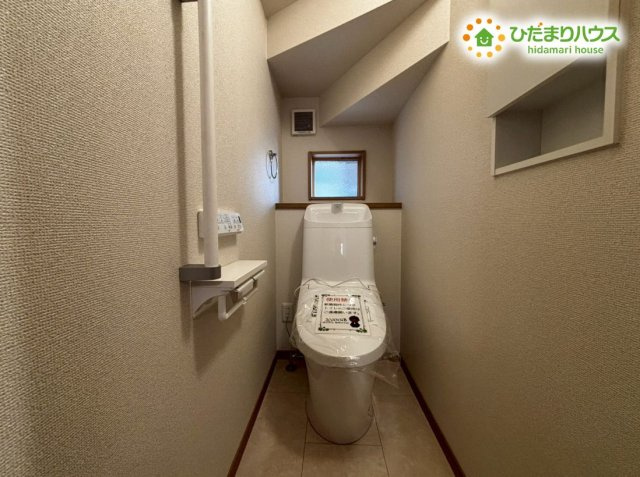 深谷市上野台　第59期　新築一戸建て　ワイウッドコート　01のトイレ|清潔感のある内装に、換気がしっかり行える小窓が備わった快適なトイレです！上部の棚にはトイレットペーパーなどをスマートに保管できます！