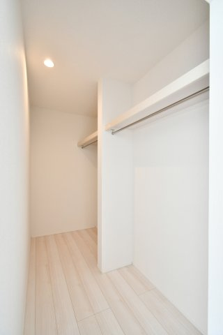 久喜市青葉５期全２棟　１号棟の収納|【WIC】ウォークインクローゼットは枕棚＋ハンガーパイプで衣類をまとめて整理。季節家電やスーツケースも置きやすいのが魅力。通路幅や奥行き、照明位置、換気の有無は現地でご確認を。収納量の目安に。