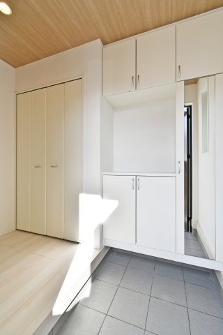 久喜市青葉５期全２棟　１号棟の玄関|【玄関収納】大型の玄関収納＋姿見で身支度がスムーズ。土間側の汚れ対策もしやすい配置です。棚の可動範囲や収納量、鏡の位置関係、玄関幅の体感や採光は現地で確認ください。コート掛けも想定を。